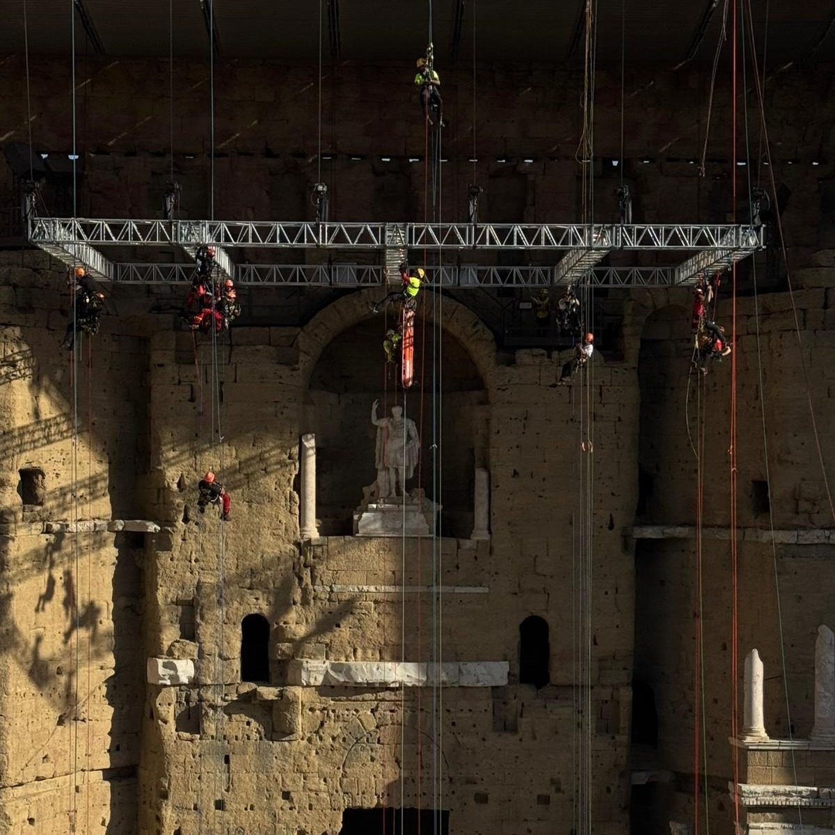 Técnicos de acceso por cuerda trabajando en la fachada del teatro romano de Orange durante el Vertical Day 2026
